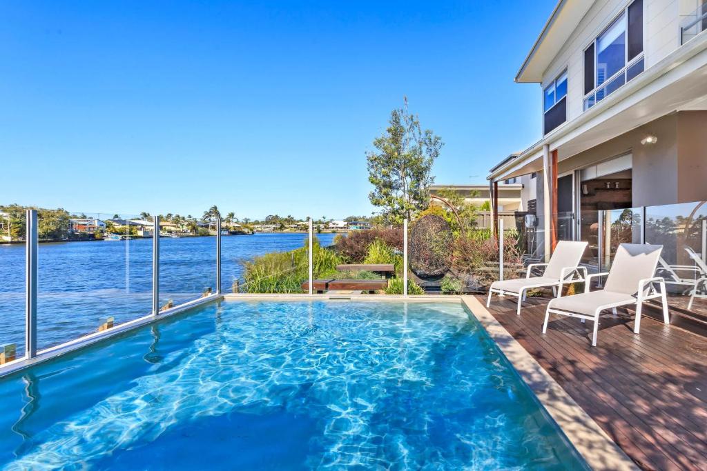 una piscina en una casa con vistas al agua en Luxurious Waterfront Paradise Stunning Views, en Kawana Waters