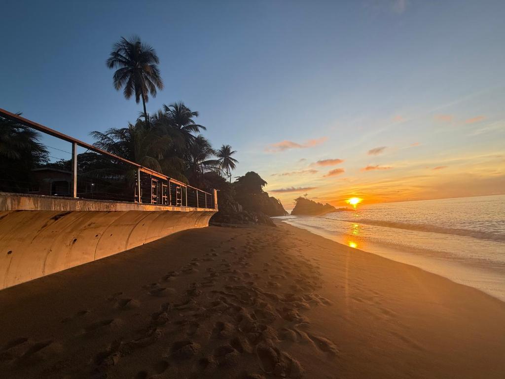 a bridge over a beach with a sunset in the background at Birdies Nest Upper 2 Bedroom Beach View in Black Rock