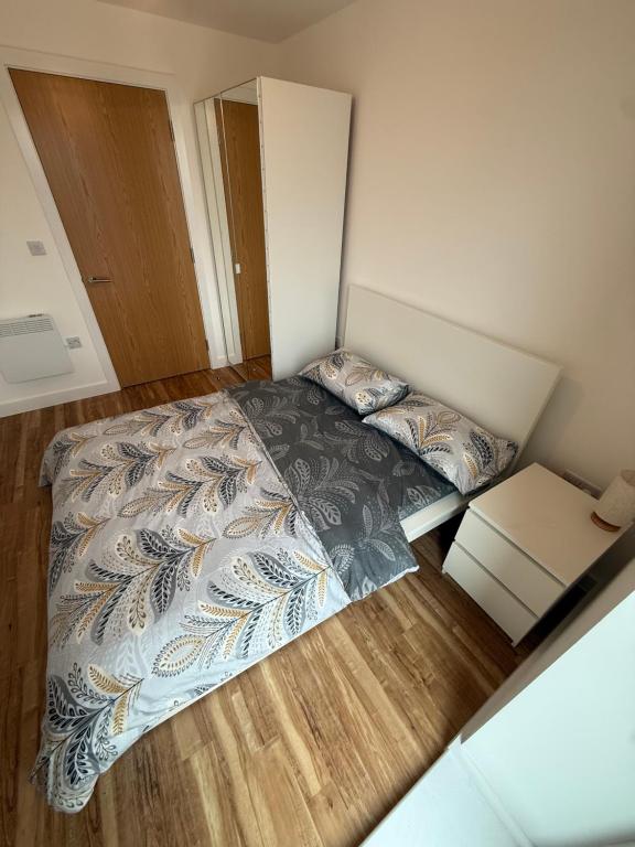 a small bedroom with a bed and a wooden floor at A s Crib in Manchester