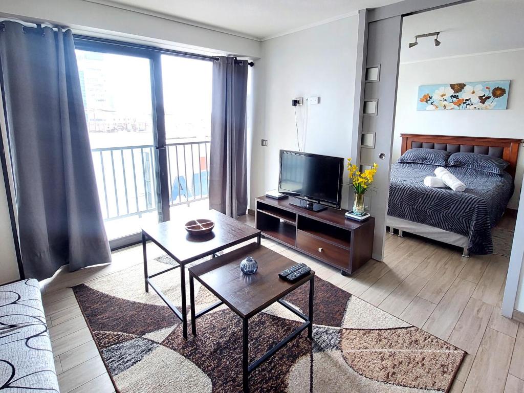 a living room with a bed and a television at Departamento Centro Vista al mar 1D 1B in Antofagasta