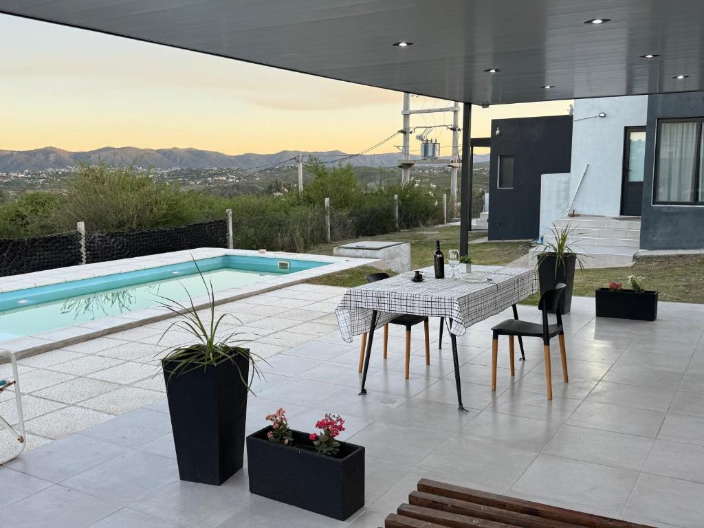 a patio with a pool and a table and chairs at Casa Carlos Paz, 6 personas in Estancia Vieja