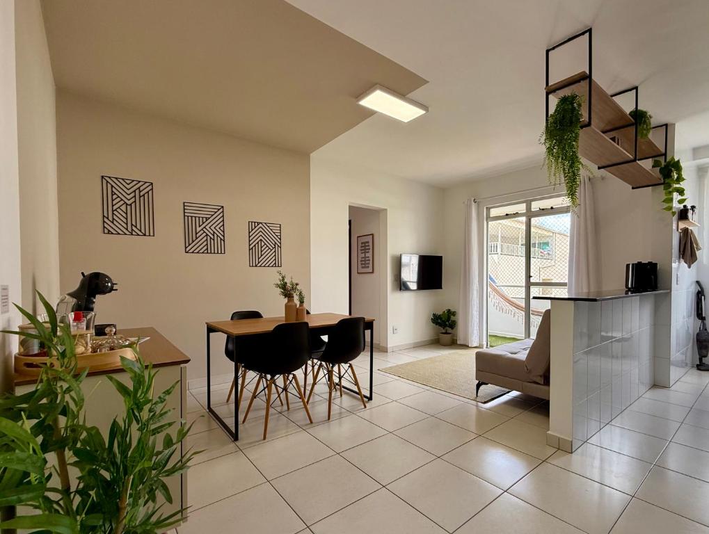 a kitchen and living room with a table and chairs at Apartamento central com ar condicionado e 3 smart TVs - UFV a 1km in Viçosa