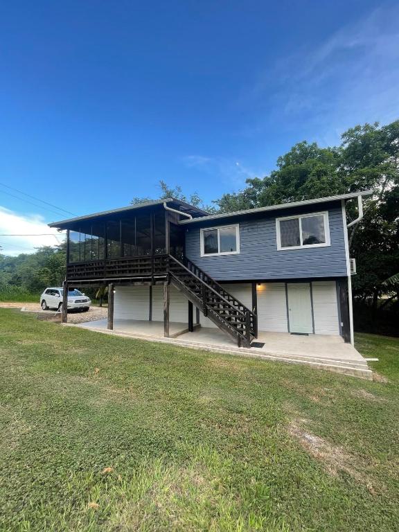 Spanish LookoutBlue House Bungalow的带阳台的房子和门前的停车位