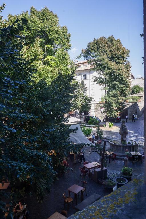 a view of a courtyard with tables and trees at Casa Vacanze Ponte del Duomo in Viterbo