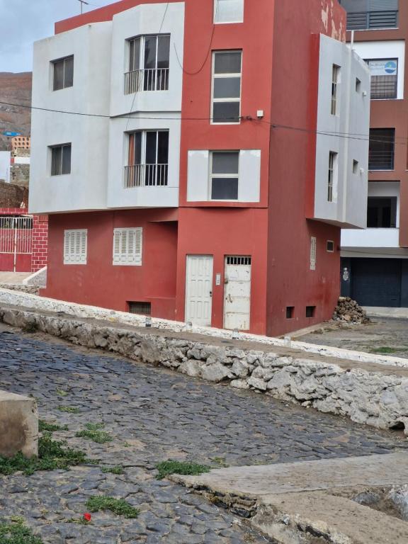 a red and white building next to a street at T3 Mindelo in Mindelo