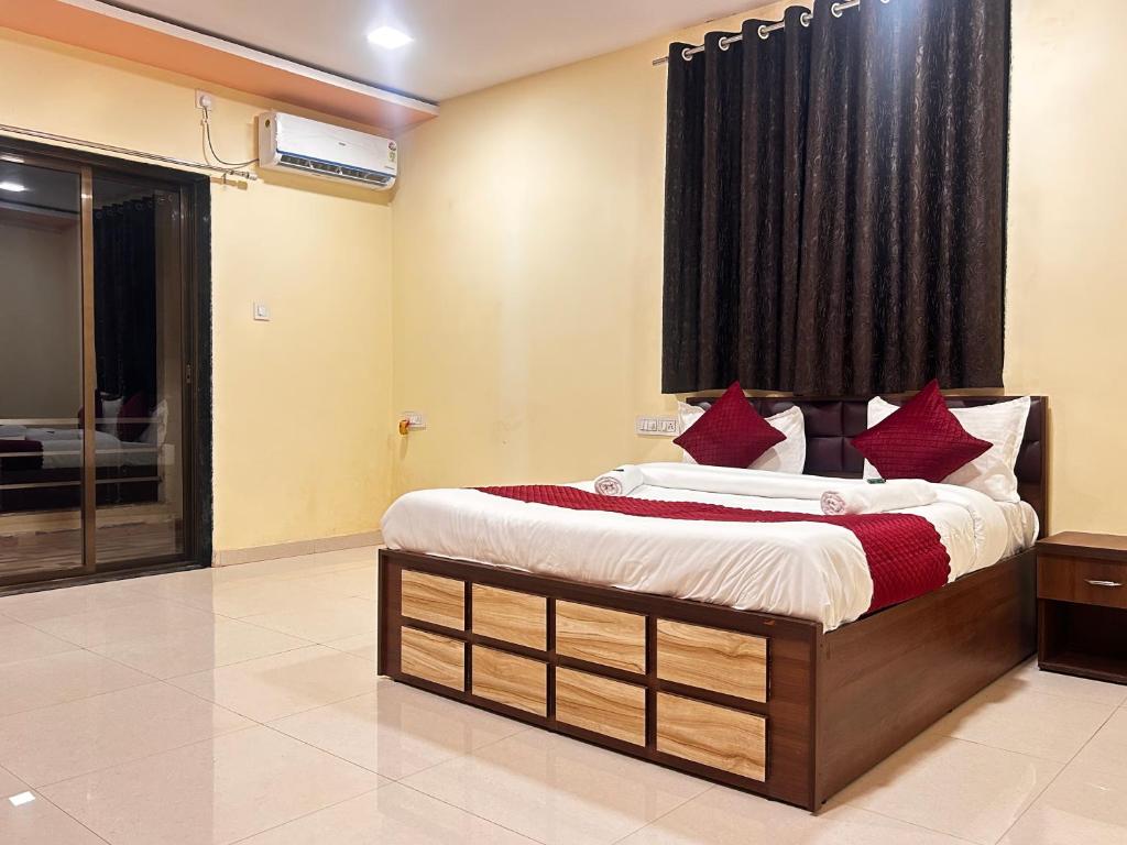 a bedroom with a large bed with red pillows at 7 Hill Stays in Panchgani
