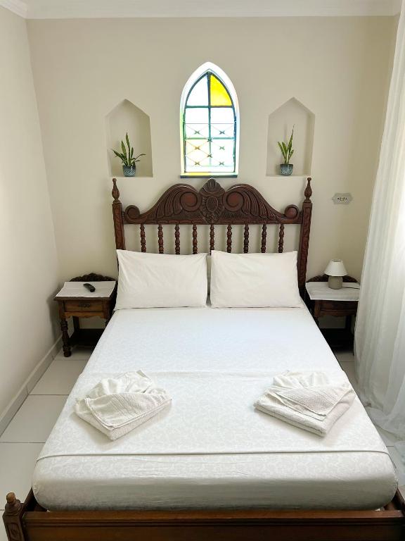 a bedroom with a bed with two towels on it at Hostel Castell Di Madre in Santos