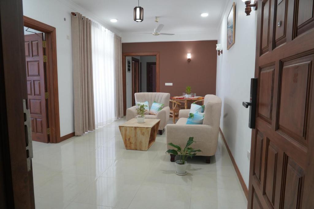 a hallway with a living room with chairs and a table at Modern 3 BR Apt in Dehiwala