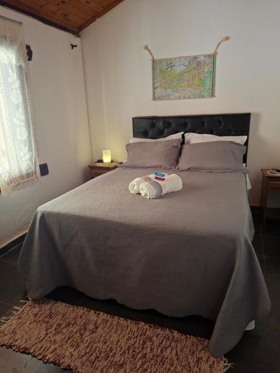 Un dormitorio con una cama con una toalla encima. en Chalé Beira Rio Cipó, en Serra do Cipo