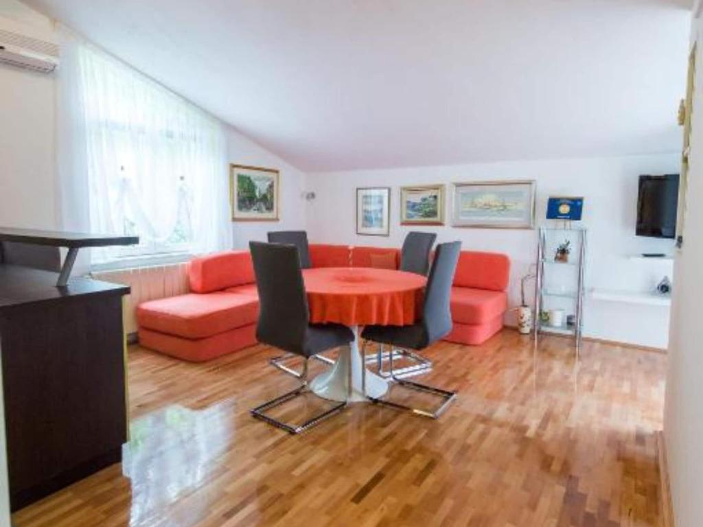 Una sala de estar con una mesa roja y un sofá. en One-Bedroom Apartment With Lake View, en Bara