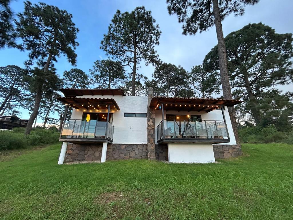 a house with two balconies on a grass field at Cabaña DAGO in Mazamitla