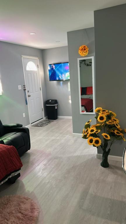sala de estar con sofá y jarrón de girasoles en Unit #10 Private Studio, en Hempstead