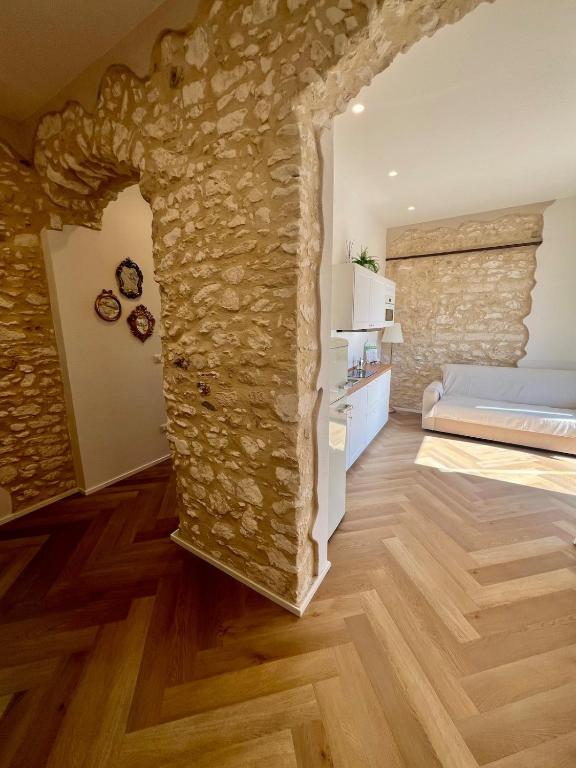 a living room with a stone wall and a bed at Cuore Antico - Il Monastero Sul Mare in Vieste