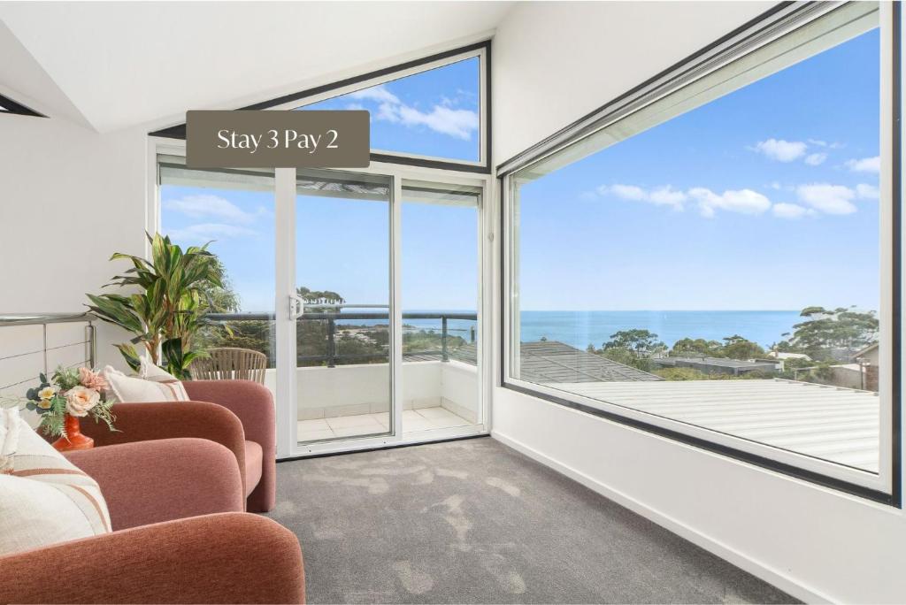 a living room with a view of the ocean at Beleura Views in Mornington in Mornington