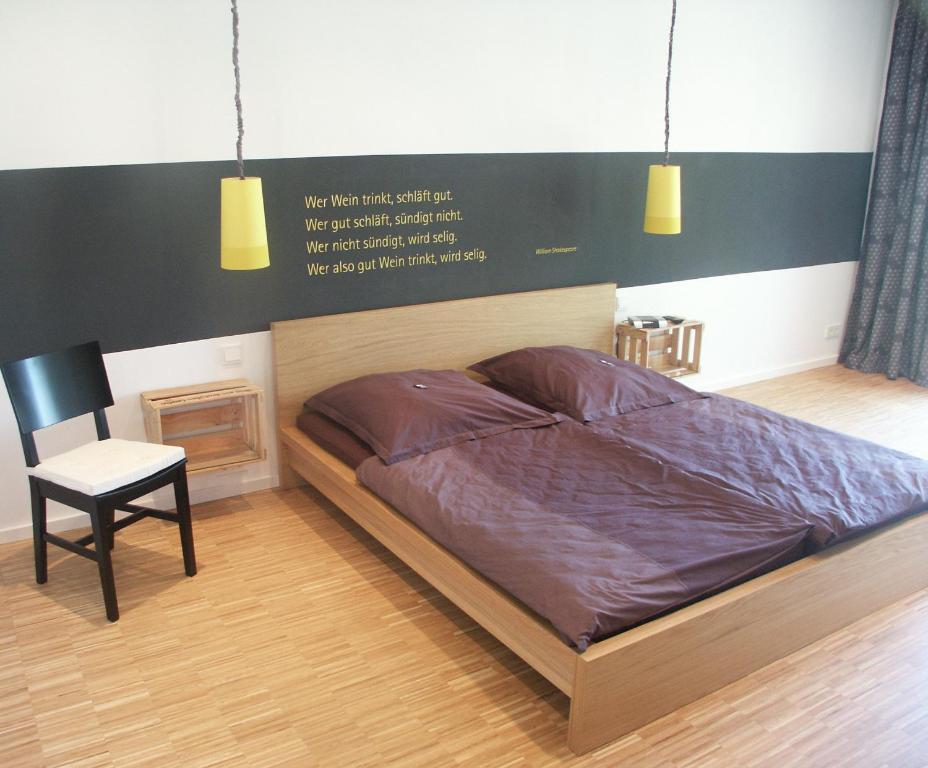 a bed in a room with a chair and lights at Weingut Seck in Dolgesheim