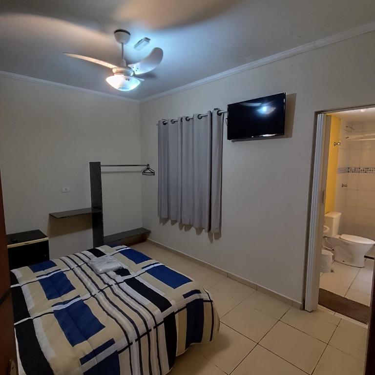 a bedroom with a bed and a tv on the wall at Hotel do Museu no ipiranga com TV ventilador banheiro in São Paulo
