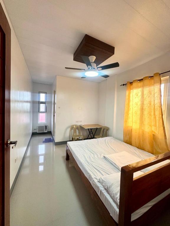 a bedroom with a bed and a ceiling fan at JEMZ Tagaytay Budget Transient in Kaybagal