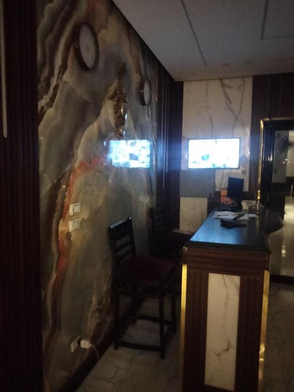 Una oficina con una pared, un escritorio y un reloj. en Host G Hotel, en El Cairo