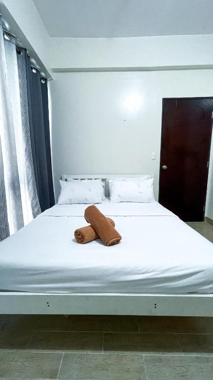 a white bed with a towel laying on it at 13 Twin Balcony Escape in Iloilo City