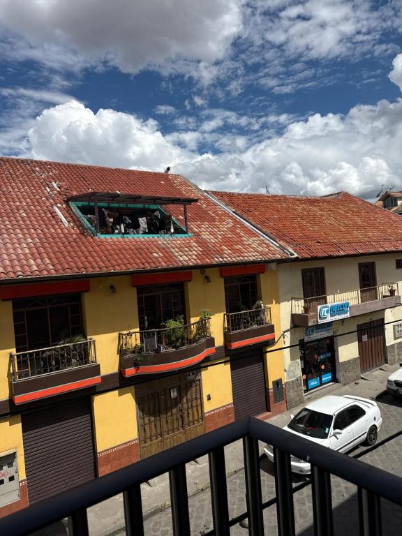 a building with a car parked in front of it at Encanto Colonial Apartamento Centro Histórico in Cuenca
