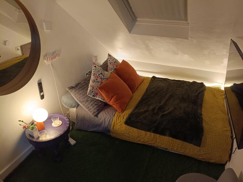 a bedroom with a bed with pillows and a table at The Snug in a Quaint English Mews House in London