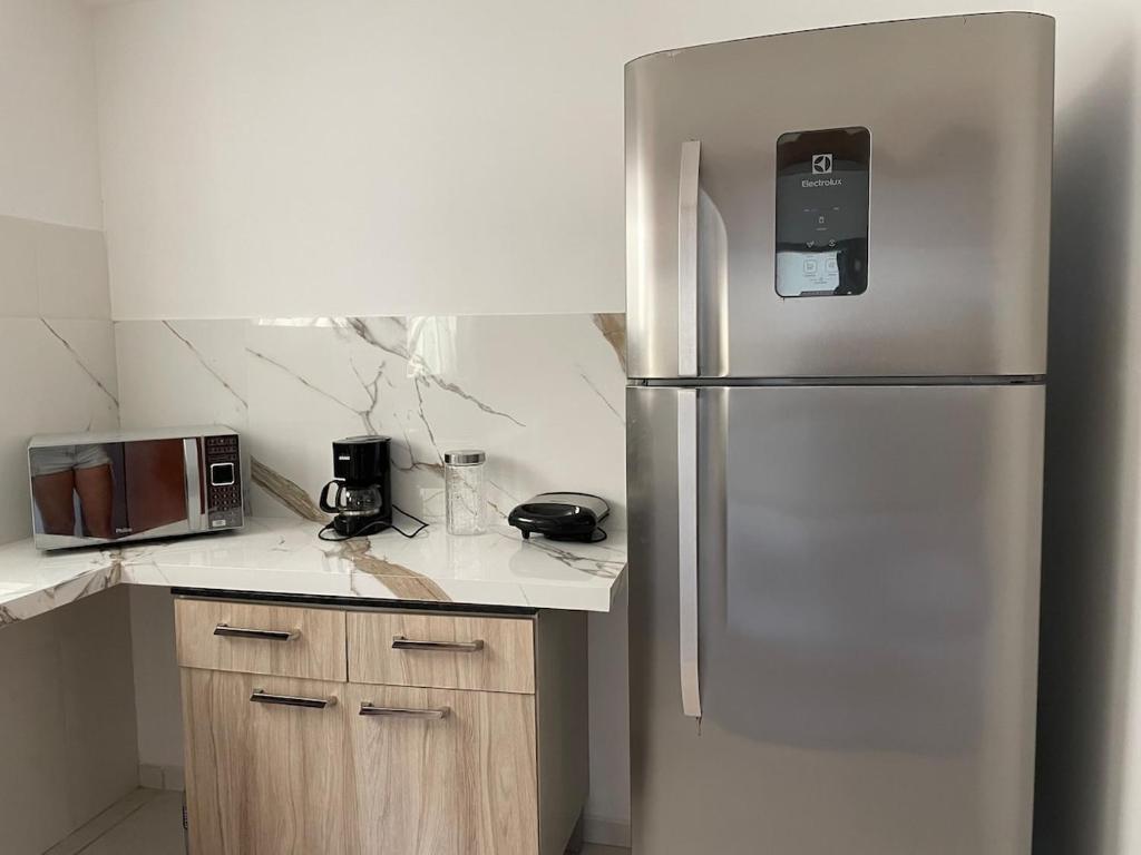a kitchen with a stainless steel refrigerator in a kitchen at Comfort and good memories, right by the lagoon! in São Pedro da Aldeia