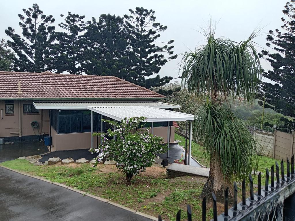 a house with a white roof and a palm tree at The Deyzel House in Durban