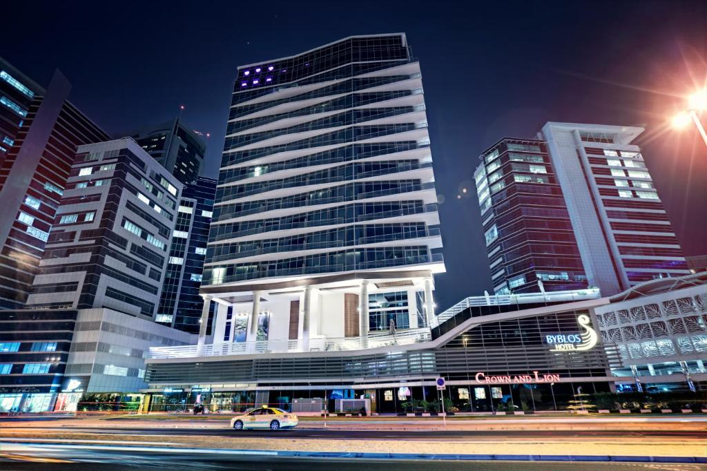 a city at night with a car in front of buildings at Byblos Hotel in Dubai