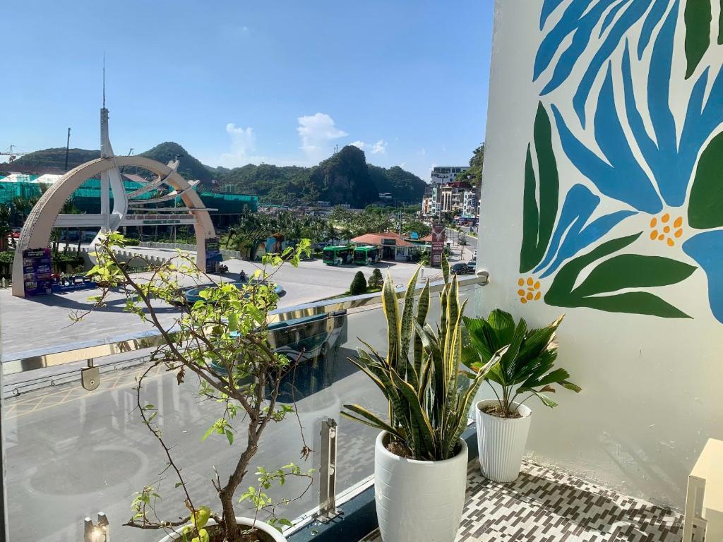 a balcony with potted plants and a view of a city at CatBa Pod Hostel in Cat Ba