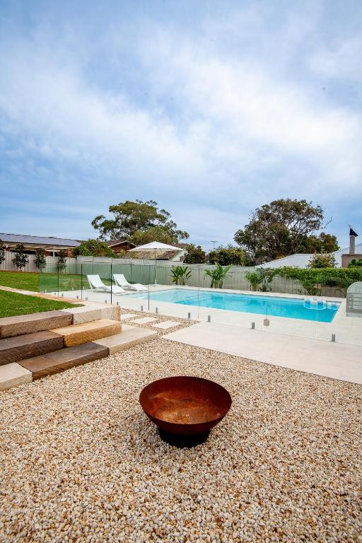 a bowl on the ground next to a swimming pool at Illaroo House in Shoal Bay