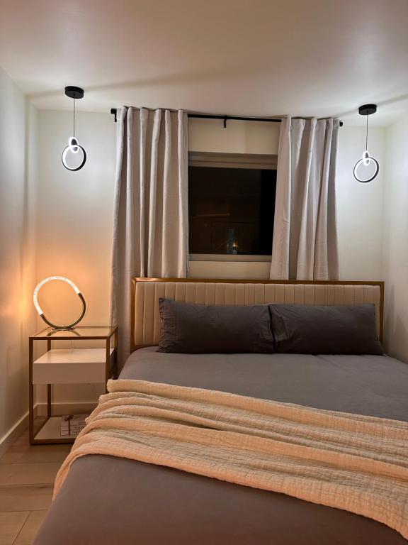 a bedroom with a bed with a window and two lights at Private Parking KING BED Urban Nest in Pittsburgh