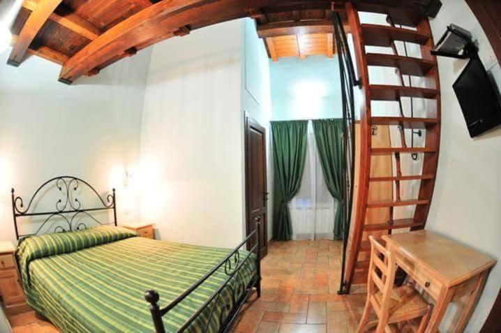 a bedroom with a bed and a spiral staircase at Azienda Agrituristica La Valle del Sambuco in Norcia