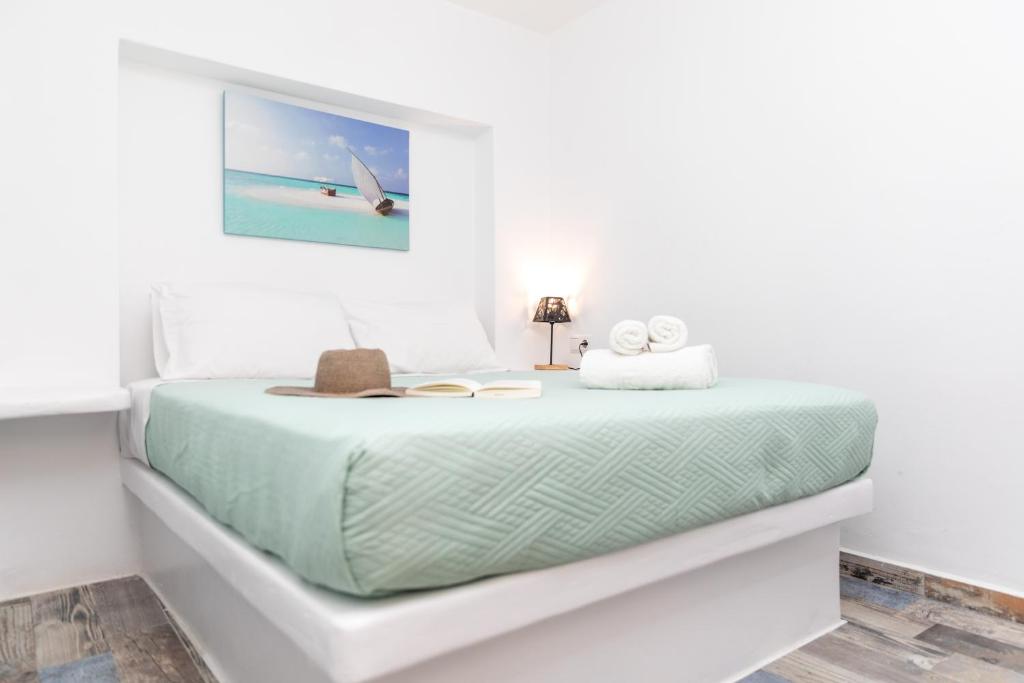 Un dormitorio blanco con una cama con toallas. en Depis luxury suites, en Naxos Chora