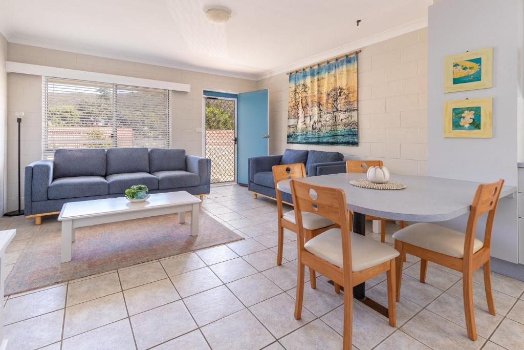 ブルーイーズ・ビーチにあるBlueys Beach Villa Manyana 25のソファとテーブルと椅子のあるリビングルーム