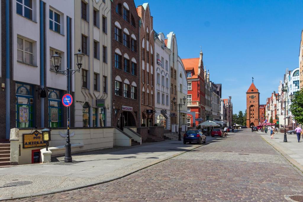 a city street with buildings and a car on the road at Apartament Stare Miasto 2 in Elblag