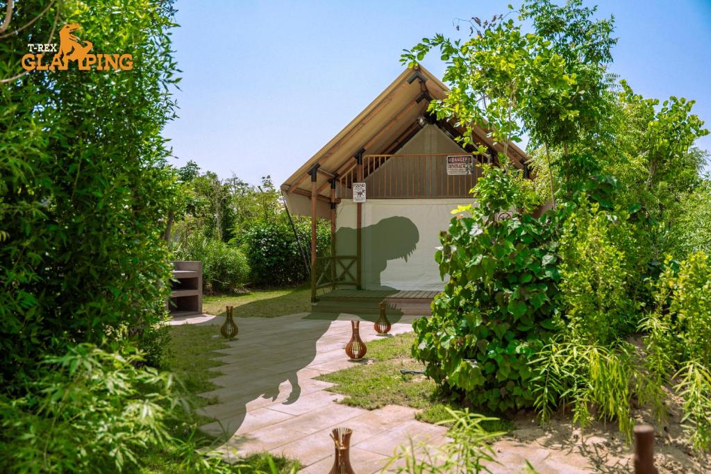 un jardín con cenador y algunas plantas en T-Rex Glamping, en Dubái