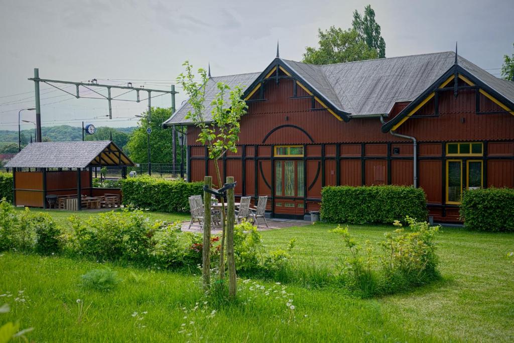 a large red barn with a table and chairs in a yard at Halte Sint-Gerlach Holiday Home in Valkenburg