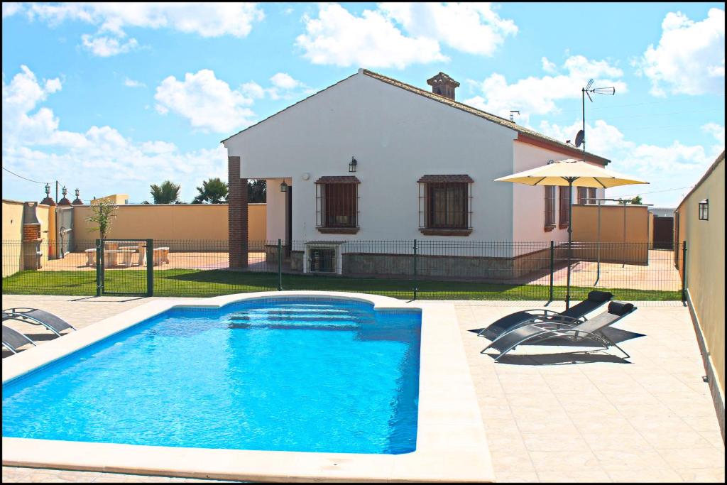 una piscina frente a una casa en Chalet Vigía 114, en Conil de la Frontera