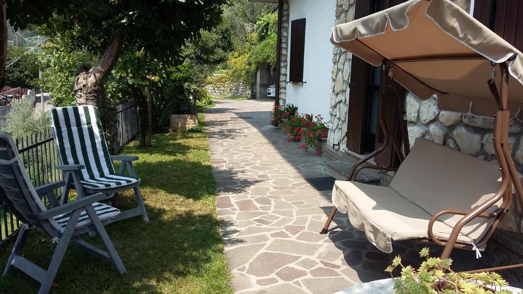 dos sillas y una sombrilla junto a una casa en Il pozzo, en Marone