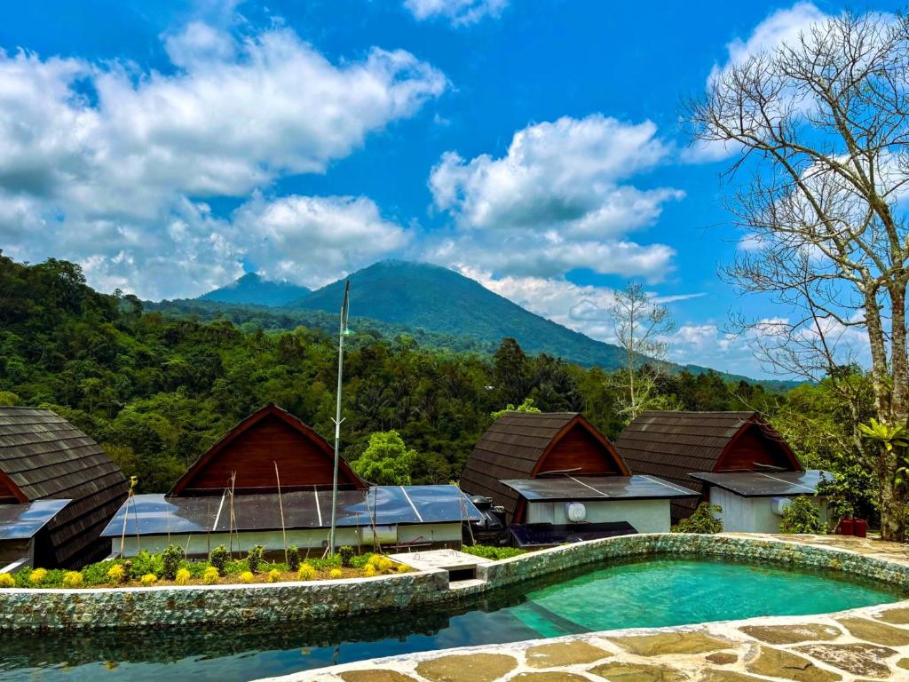 a resort with a pool and mountains in the background at Shankara Forest Haven Villa by AGATA in Jatiluwih