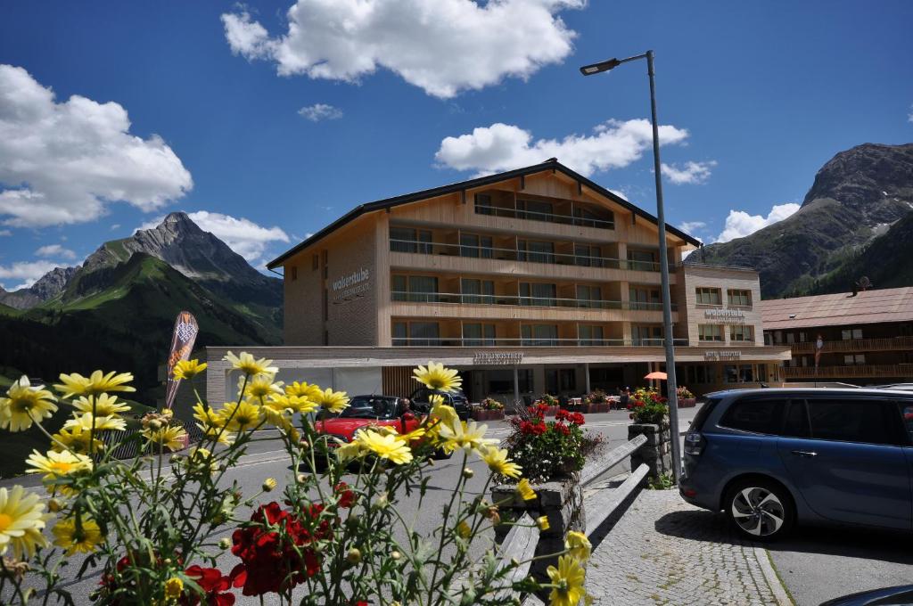 Un bâtiment avec un bouquet de fleurs devant lui dans l'établissement Hotel Walserstube, à Warth am Arlberg