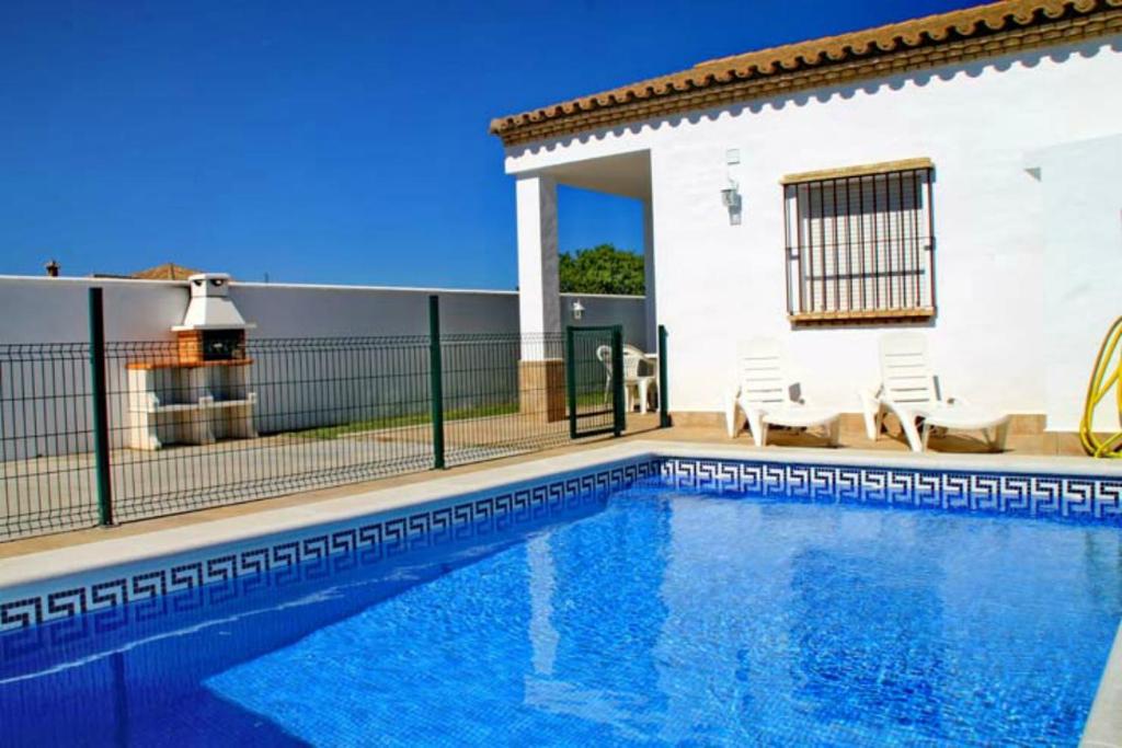 a swimming pool in front of a house at Chalet Arroyo Peñuelas 41 in Conil de la Frontera