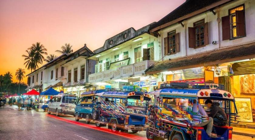 un grupo de autobuses estacionados al costado de una calle en Sysomphone G.H, en Luang Prabang