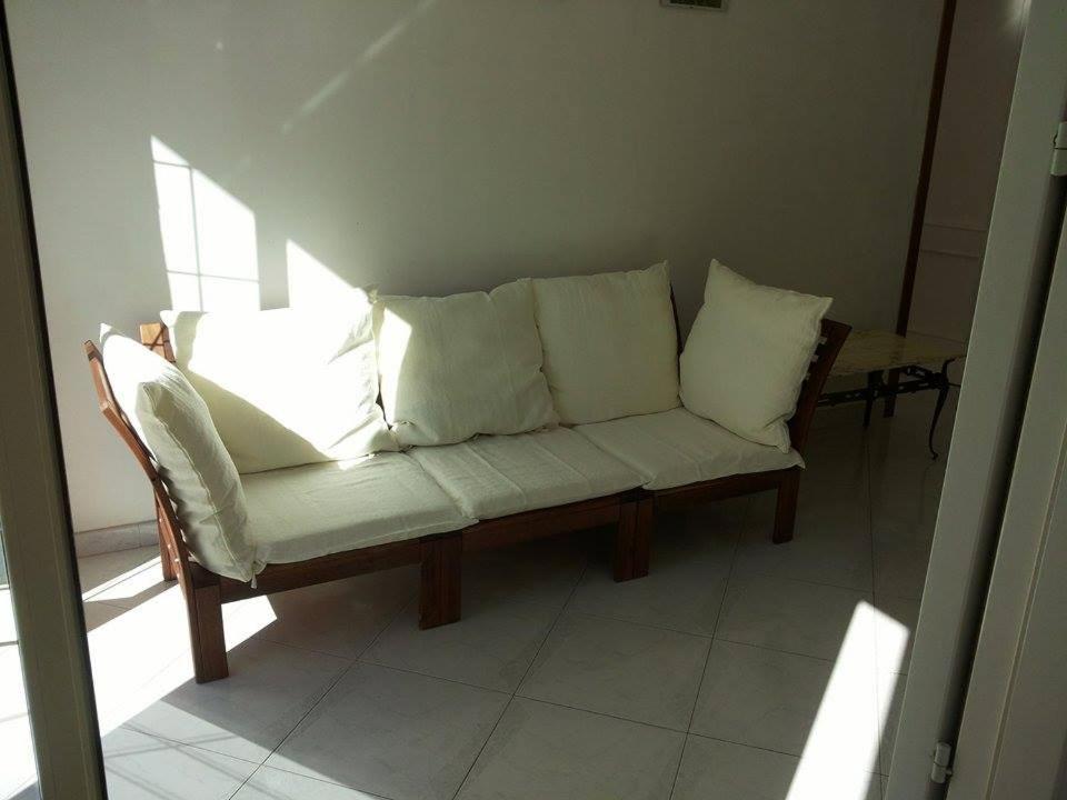 ポッツァッロにあるCasa Tre Roseの白い枕が備わるソファ(客室内)