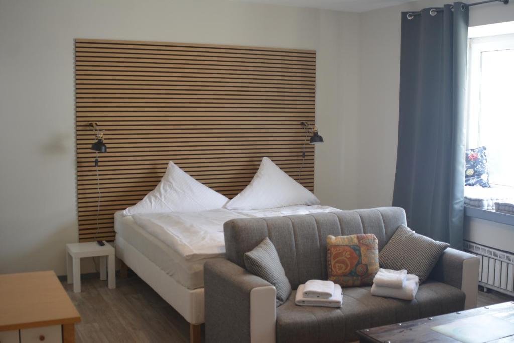 ヴォルフスブルクにあるBudgethotel Stadtbett Wolfsburgのベッドとソファのある寝室
