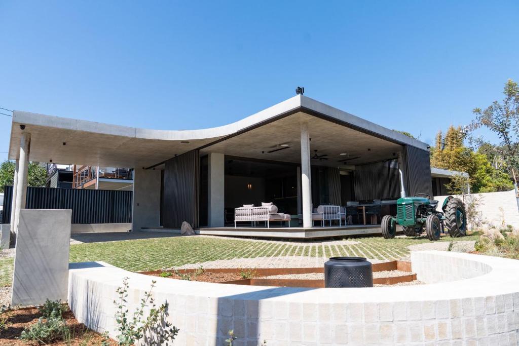 a house with a pavilion with a tractor in the yard at Arrawarra Beach House in Arrawarra