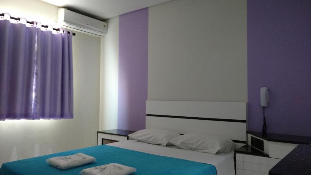 1 dormitorio con 2 camas y pared púrpura en Lider Hotel en São Bernardo do Campo