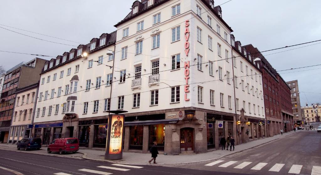 a large white building on the corner of a street at Clarion Collection Hotel Savoy in Oslo