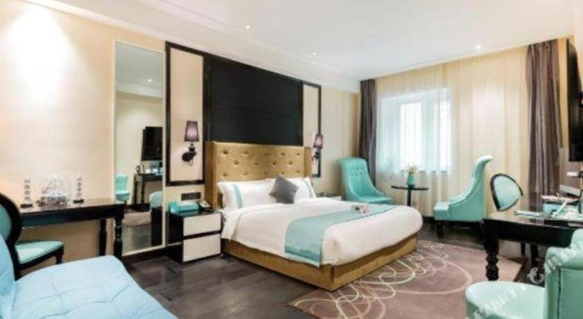 a hotel room with a bed and a desk and chairs at Xana Hotelle· Tianjin Railway Station Jinwan Square Binjiang Avenue in Tianjin