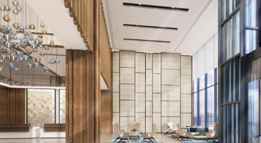 a lobby with tables and chairs in a building at Fairfield by Marriott Baoding High-Tech Zone in Ta-ma-fang